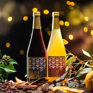 Je eine Flasche Glühwein und alkoholfreier Glühmost im Weihnachts-Dekor